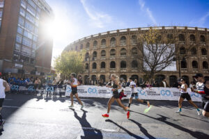 Varios corredores durante la carrera, de fondo destacan vallas publicitarias de GO2