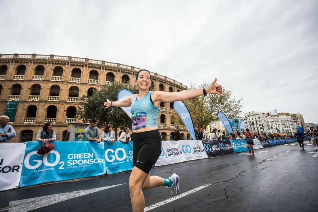 Mujer corriendo con energía y de fondo destacan las vallas publicitarias GO2